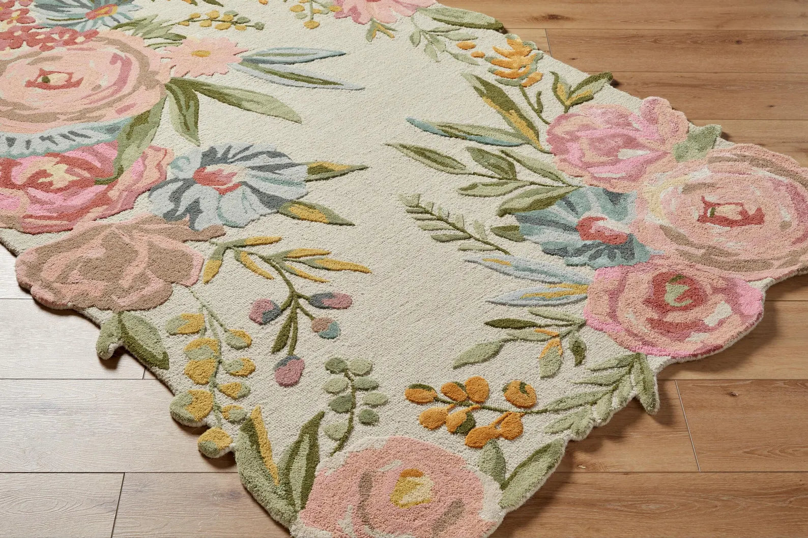 Closeup view of the Blooming Meadow hand tufted rug showing detailed floral edges on a wooden floor.