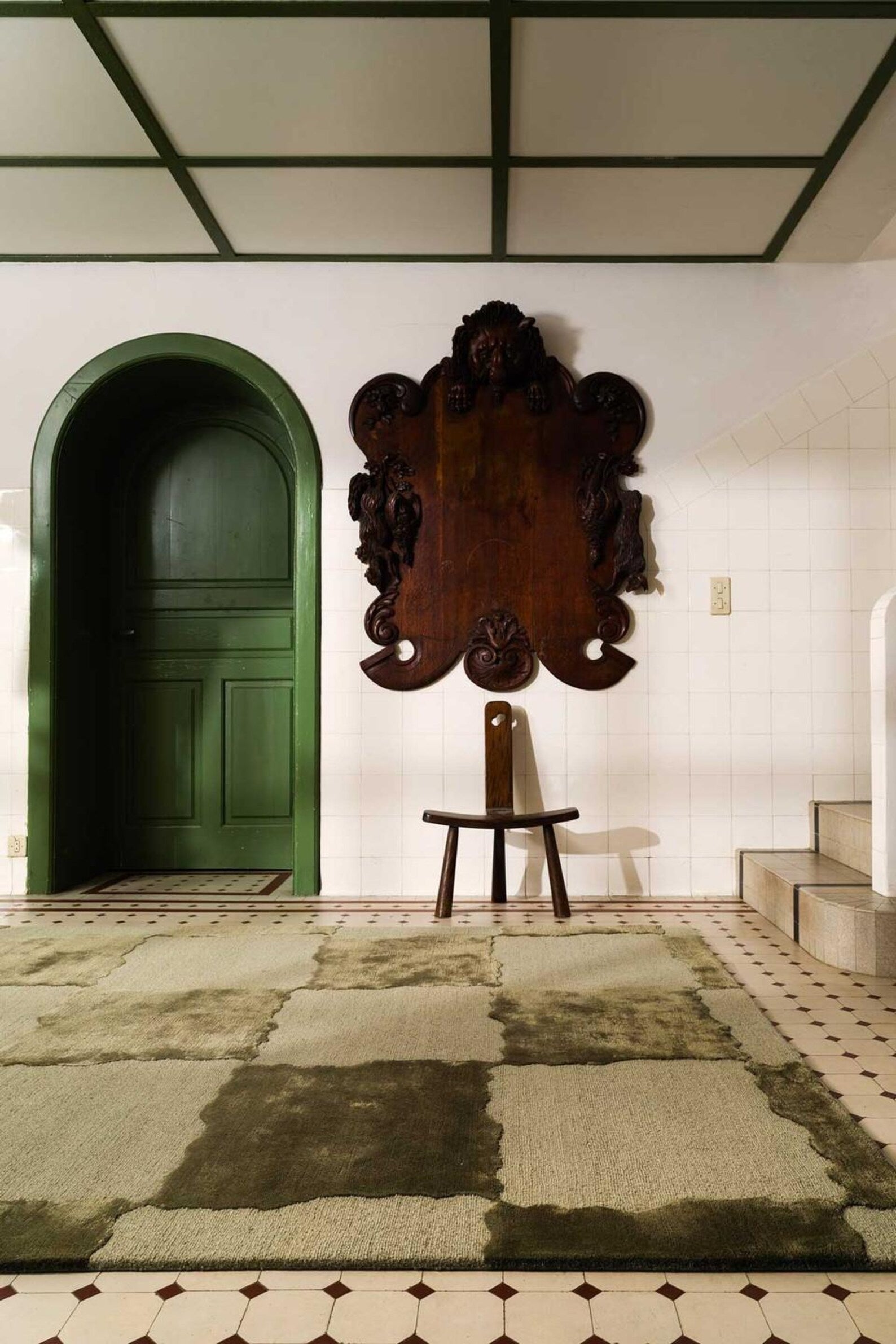 Brique hand tufted rug styled in a spacious entryway with a decorative mirror, showing full rug coverage and refined edge finish.