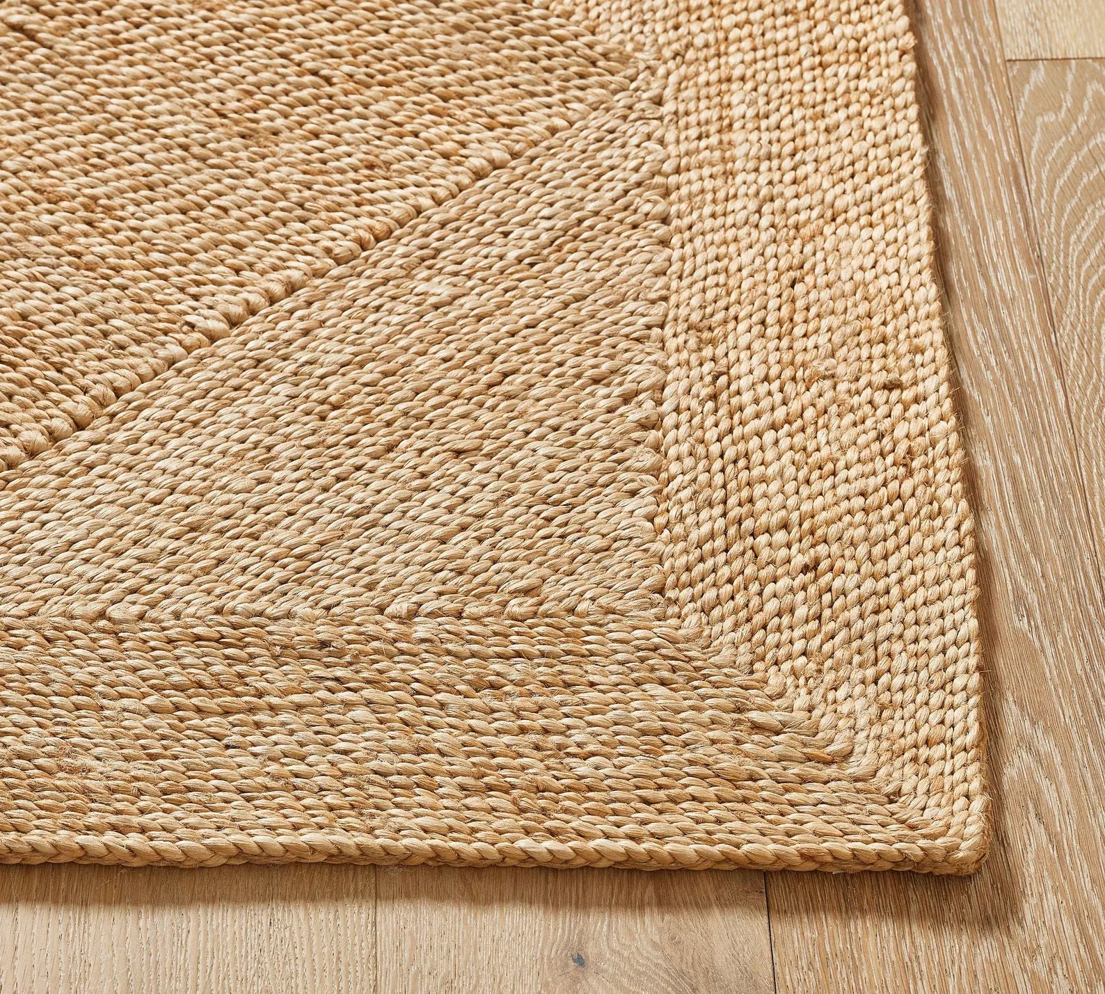 Side corner of Cascara Rug showing natural jute weaving pattern, hand-braided edges, and rustic woven texture.