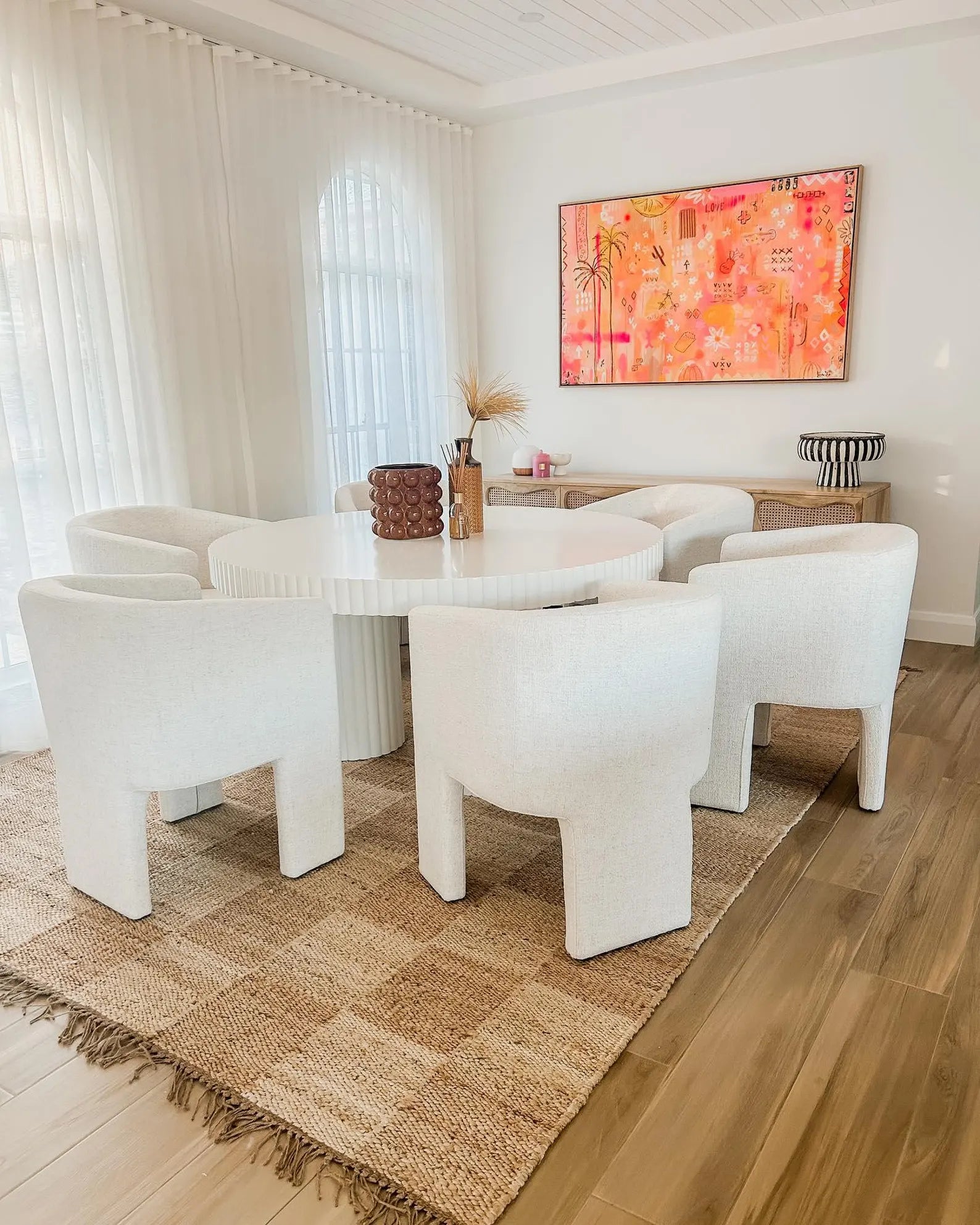 Chesson Rug styled under a dining table in a bright room, highlighting its organic beige and ivory check design with natural texture