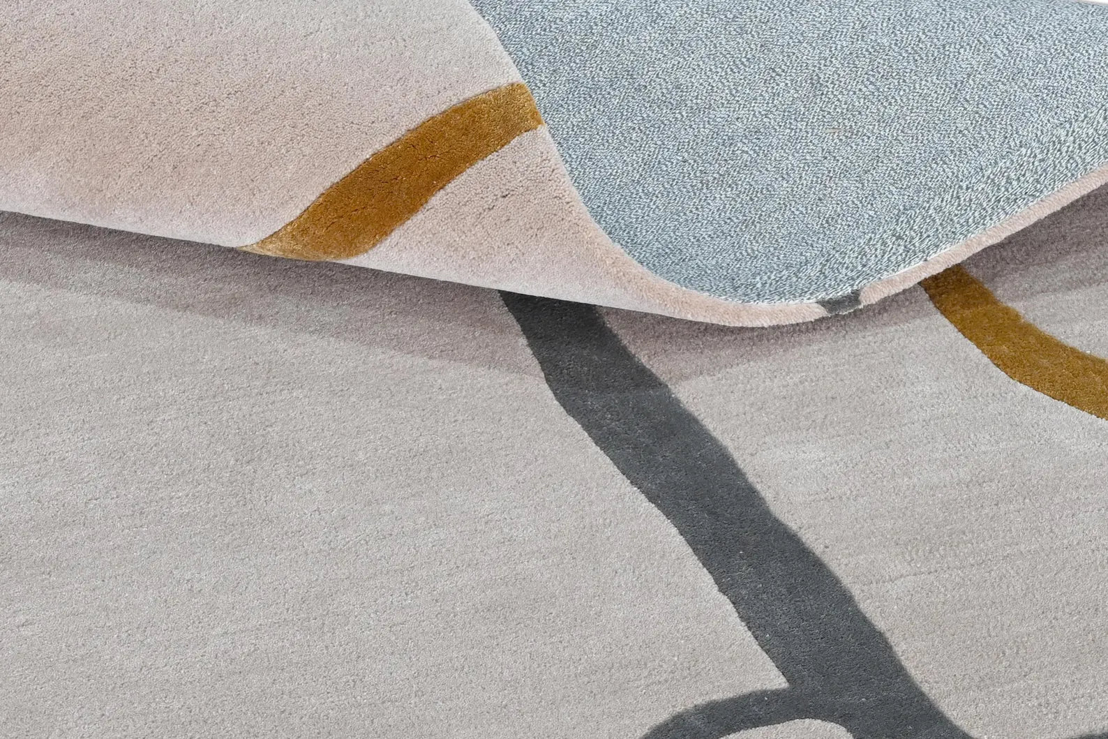 Close texture of Contour Thread Rug showing soft pile with linear thread detailing in light grey and gold tones