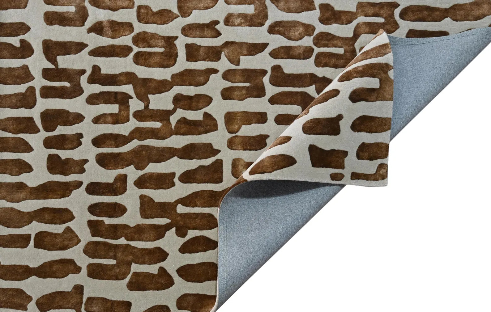 Corner fold studio view of Modern Tribal hand tufted rug showing detailed brown tribal pattern on cream base with smooth grey backing