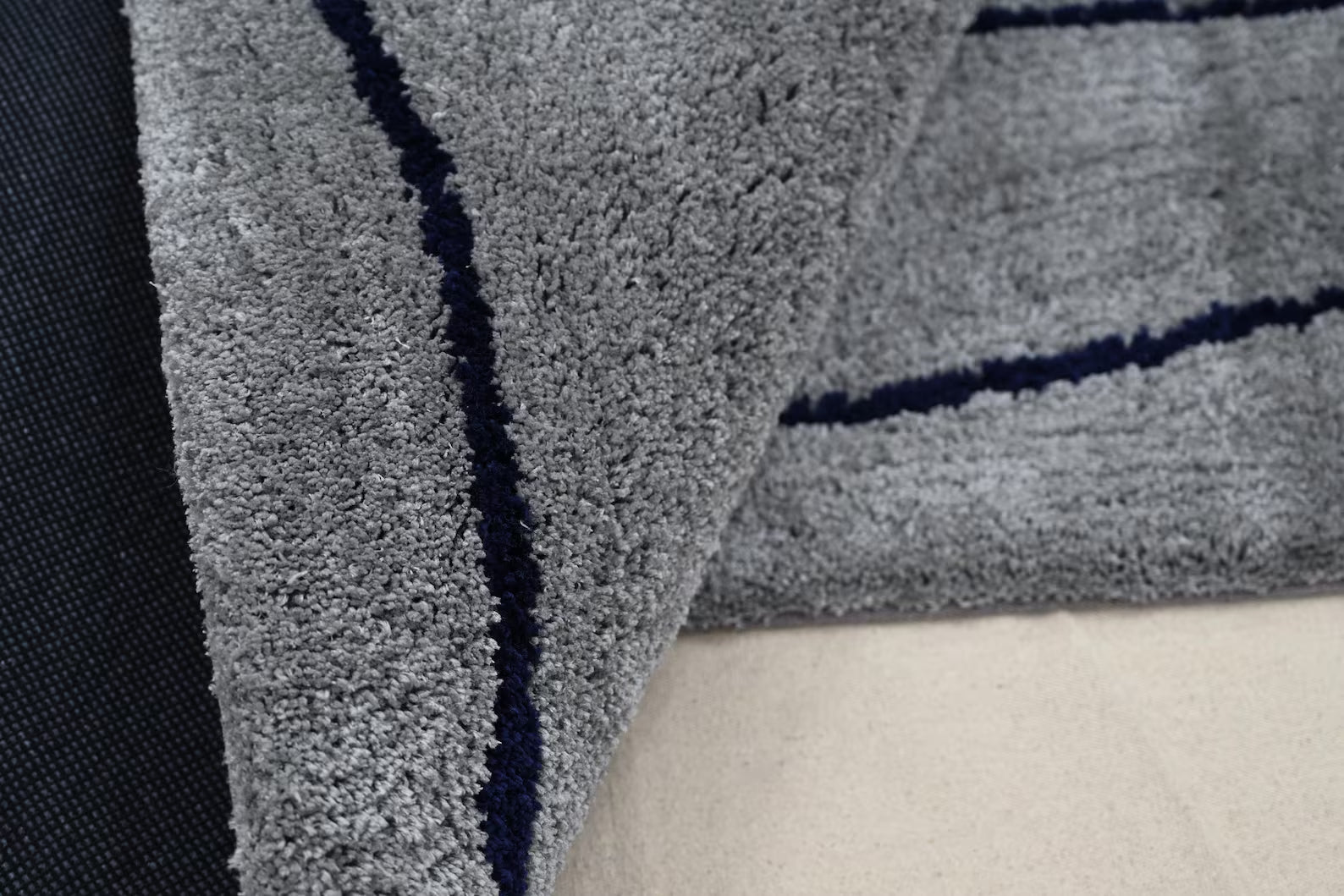 Corner fold view of Abstract Line Art Grey Rug showing smooth texture and detailed grey line art pattern