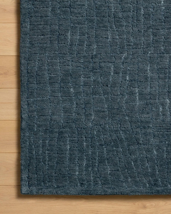 Close-up of a textured blue rug on a wooden floor