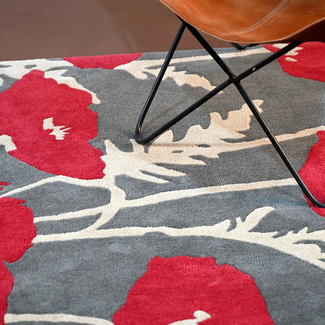 Large red poppies with ivory stems hand tufted on a soft background.