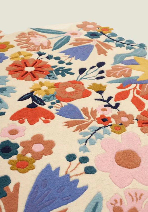 Floryn Rug close-up showing colorful floral pattern on soft beige base with detailed blooming motifs.