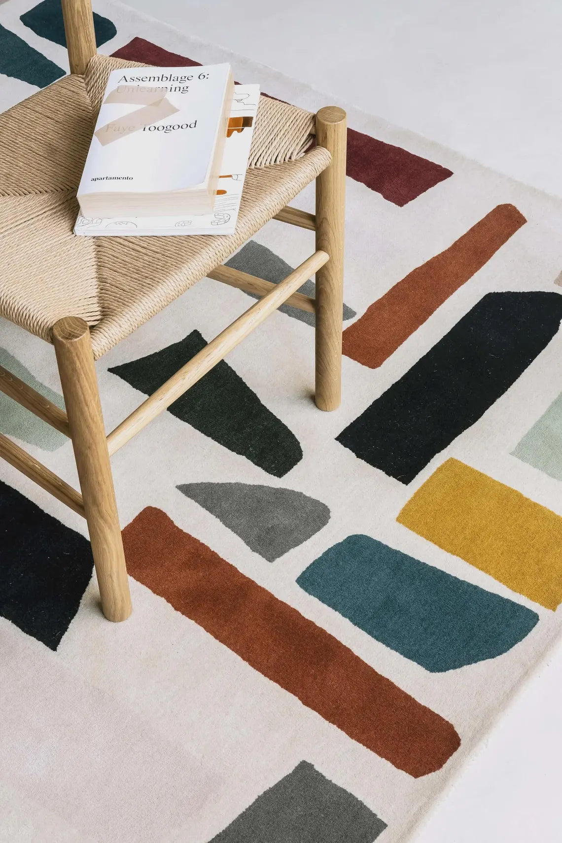 Multi-color Fragment Rug with bold abstract shapes in earthy and deep tones.