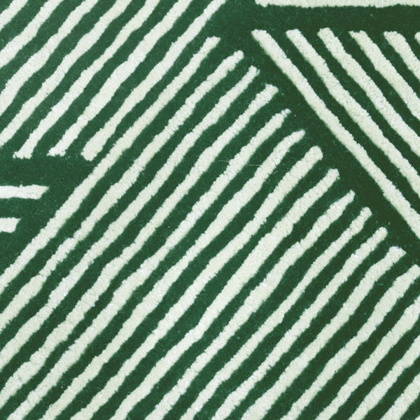 Green Terrain Rug edge detail showing precise finishing and raised tuft pattern in deep green wool texture.