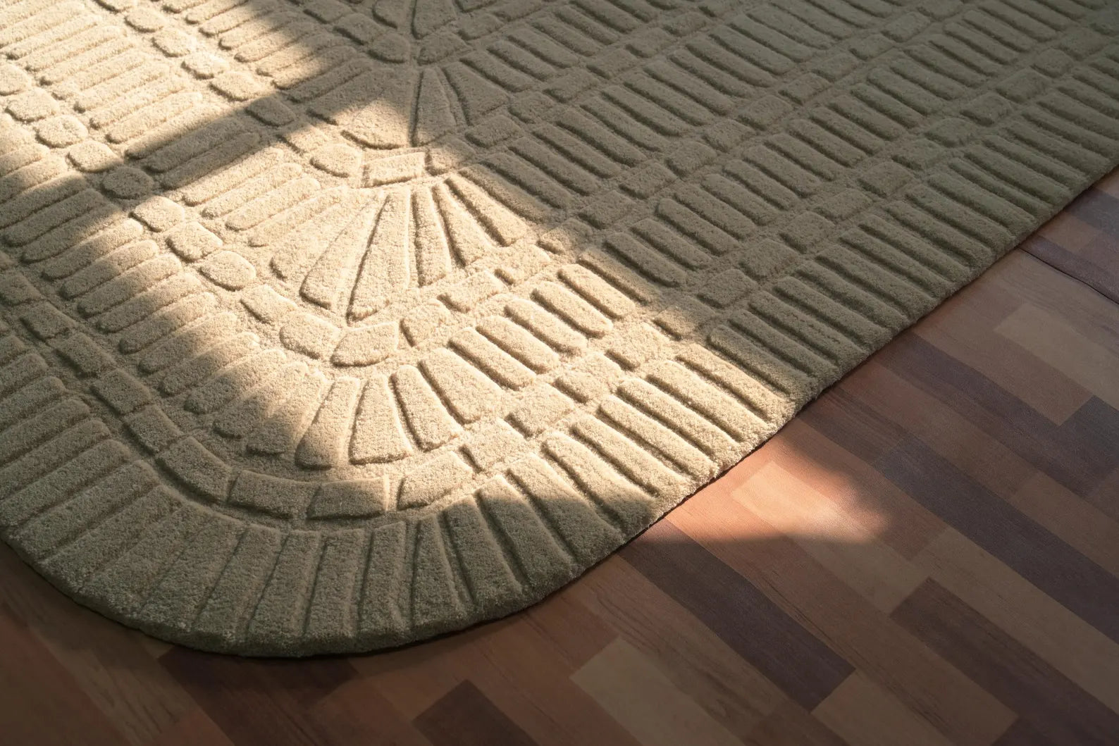 Angled shot of Grid Wool Rug with structured carved details.