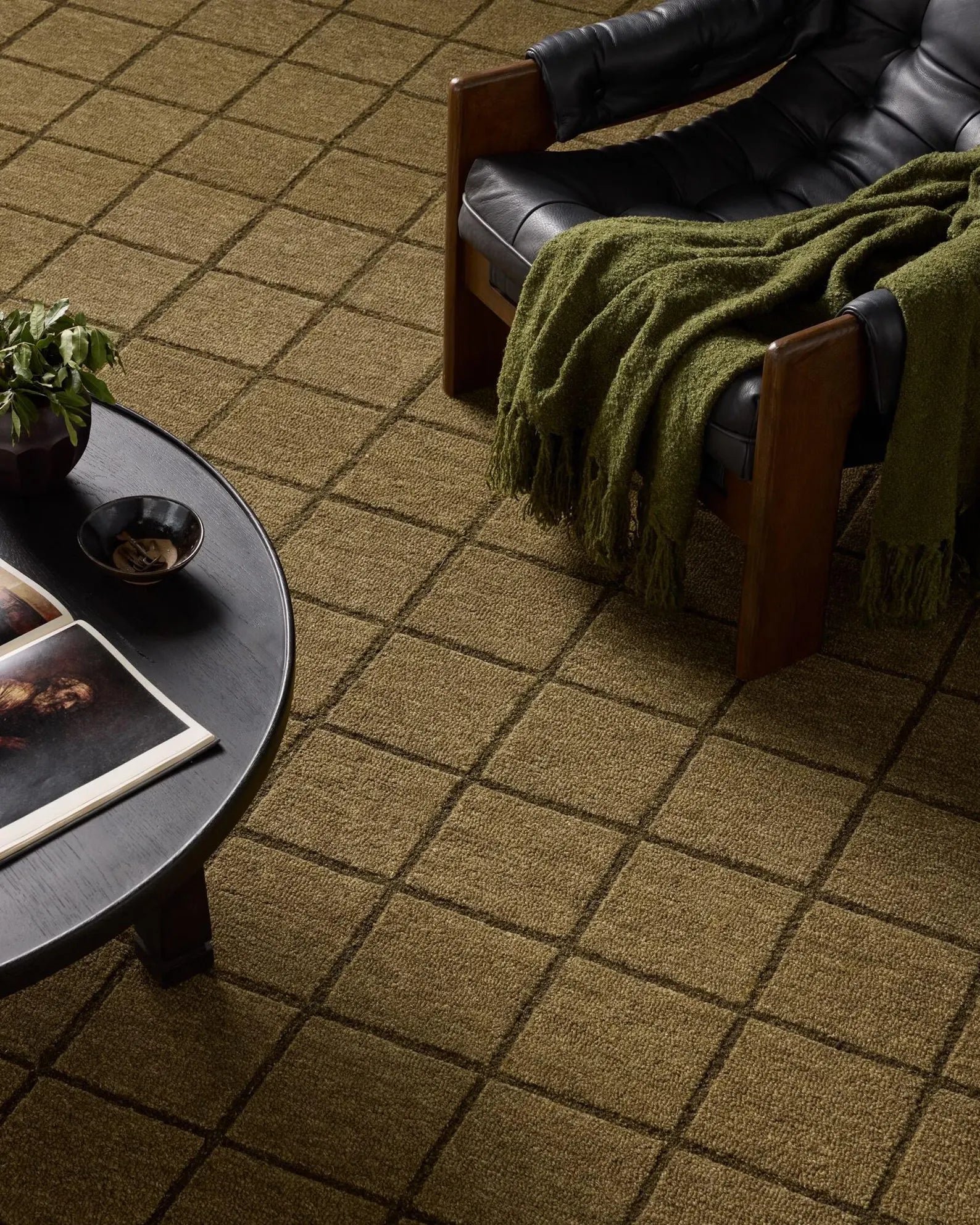 Gridform hand tufted rug in olive shown in a modern living room interior.