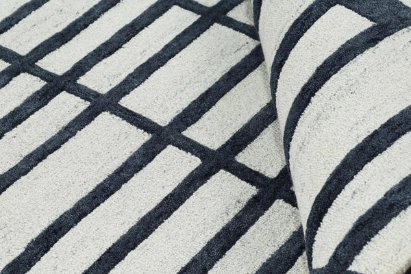 Detailed view of Gridlock Rug edge showing craftsmanship, stitching quality, and defined geometric alignment.