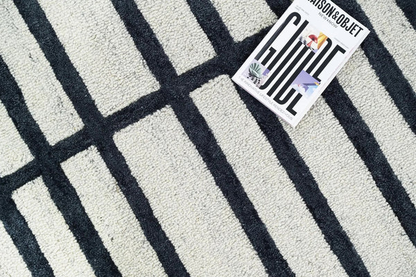 Close-up of Gridlock Rug showing raised black lines and soft wool pile on a white background.