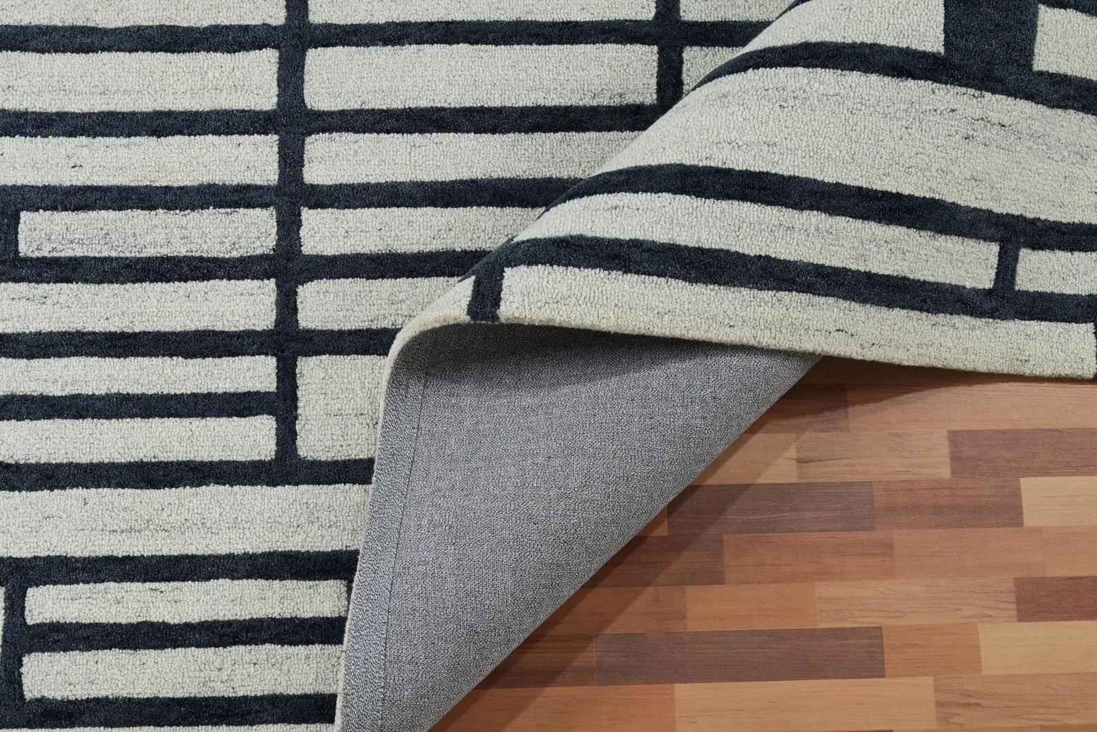 Folded edge of Gridlock hand tufted rug highlighting texture depth, smooth finishing, and hand-tufted precision.