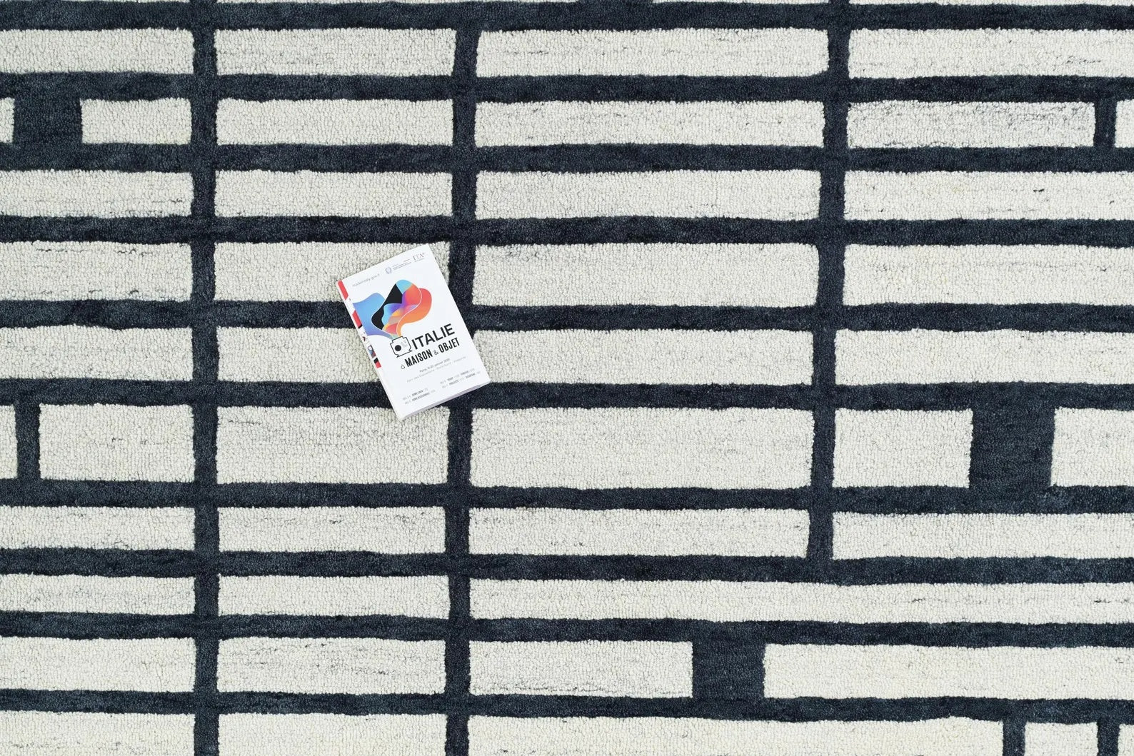 Top-angle view of Gridlock hand tufted rug displaying uniform black and white grid pattern for a clean, structured look.