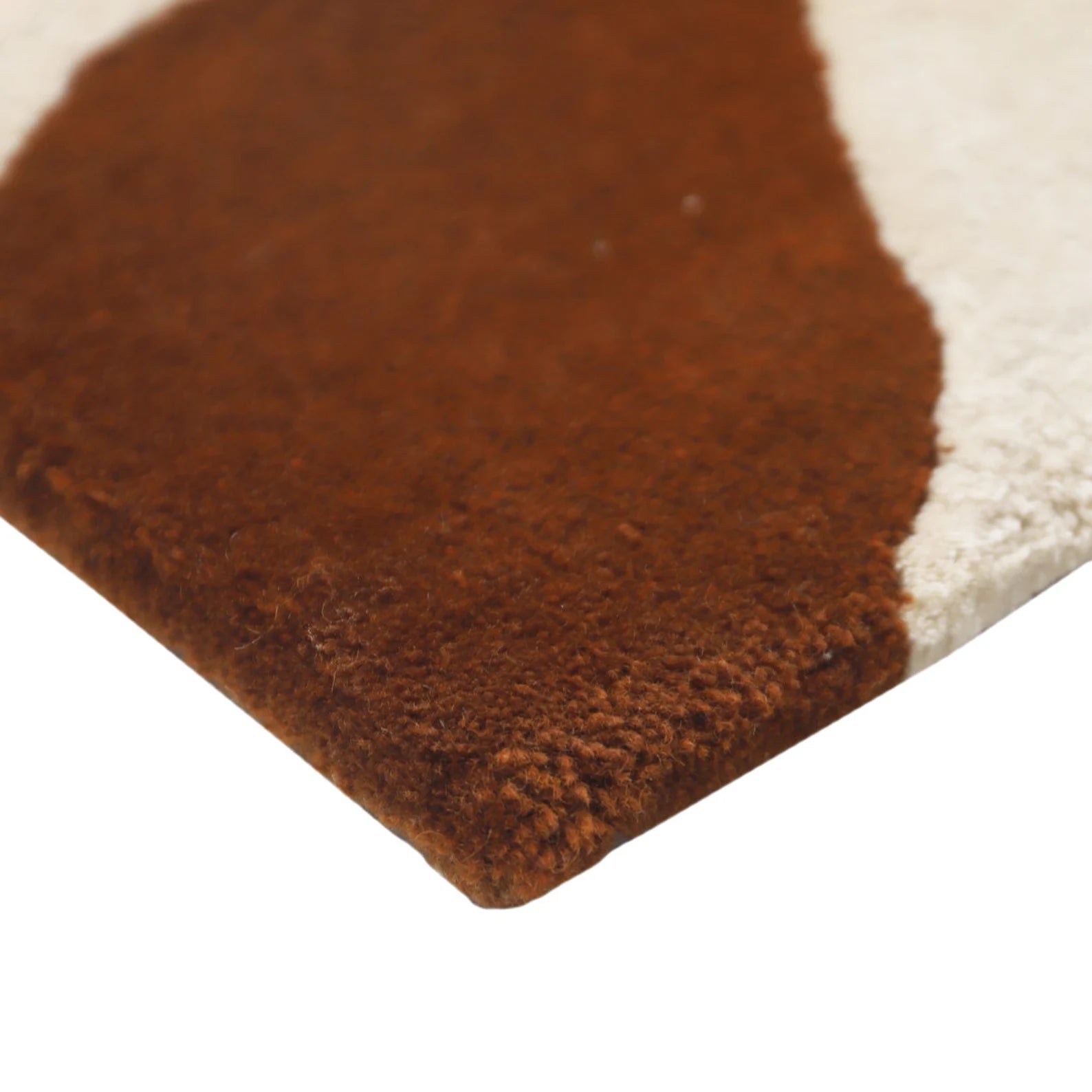 Hazel Rug corner view highlighting its soft wool texture, layered brown and beige tones, and neatly finished edges on a light background.