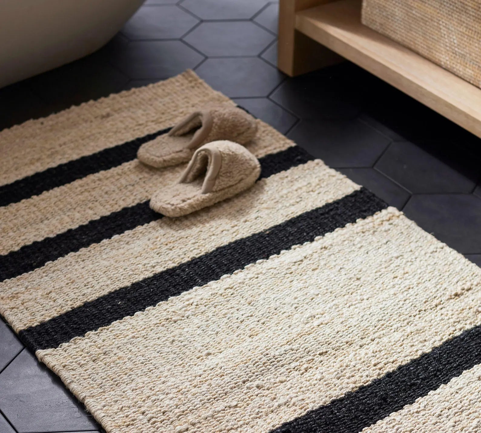 Loomtrail Rug styled beside a cozy seating area emphasizing its calm, minimal striped design.