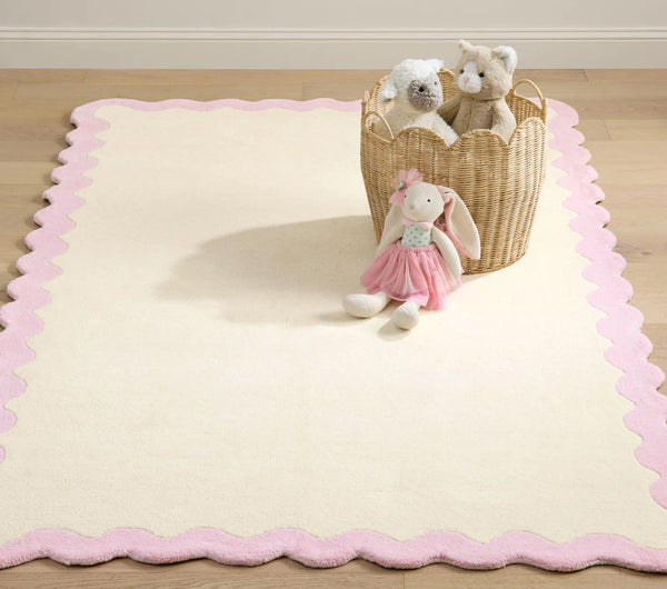 Lullaby Rug full view showing soft ivory base with pastel pink scalloped border for a gentle nursery look