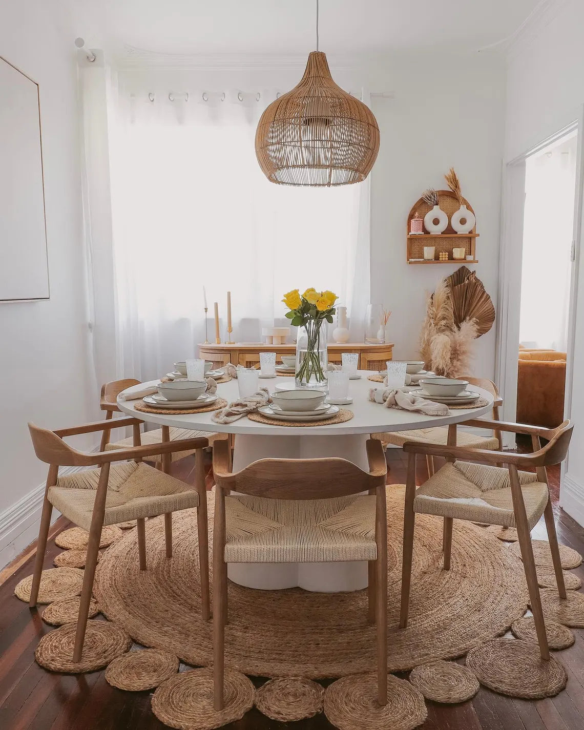 Natural jute rug in a bright seaside dining room.