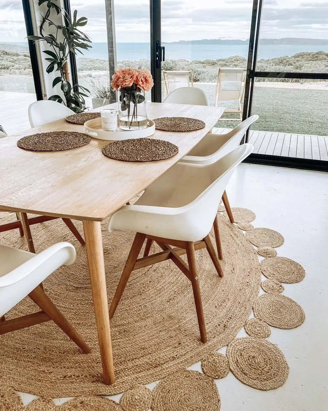 Mandala Jute Rug styled under wooden dining table.
