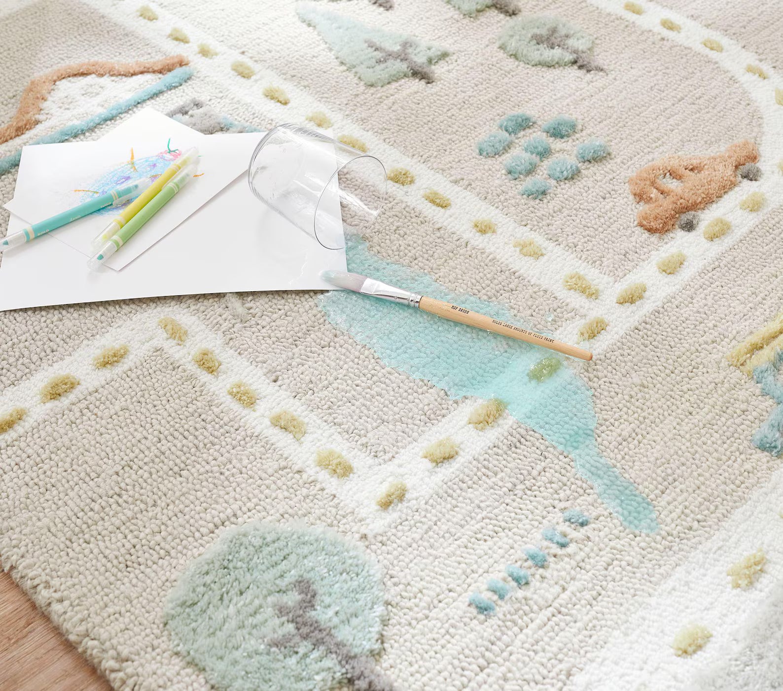 Close-up of MiniCity hand_tufted_rug showing soft hand-tufted roads, buildings, and bridges in pastel blue, beige, and cream tones.