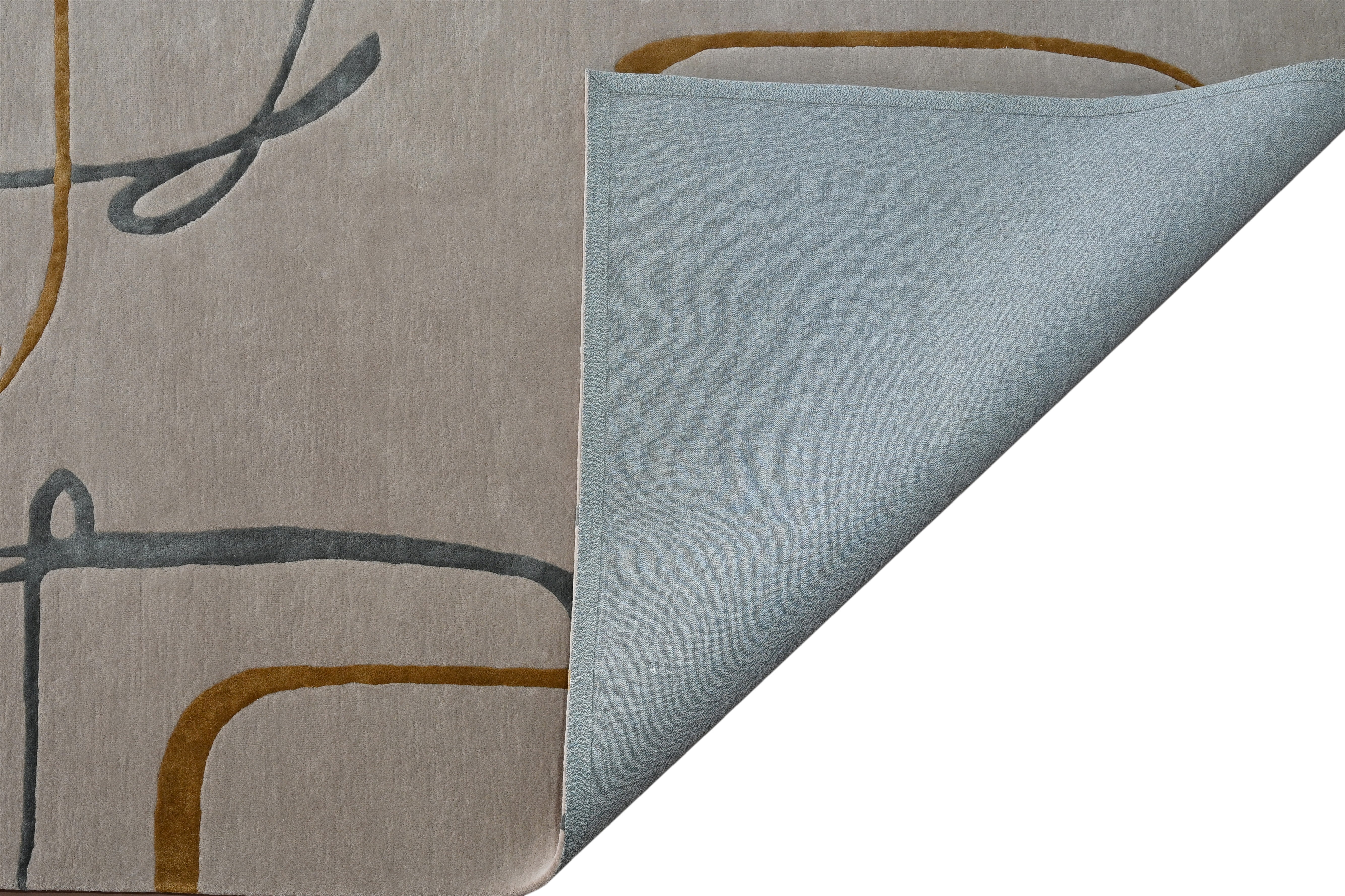 Folded corner of Muted Motion Rug showing texture and backing detail.