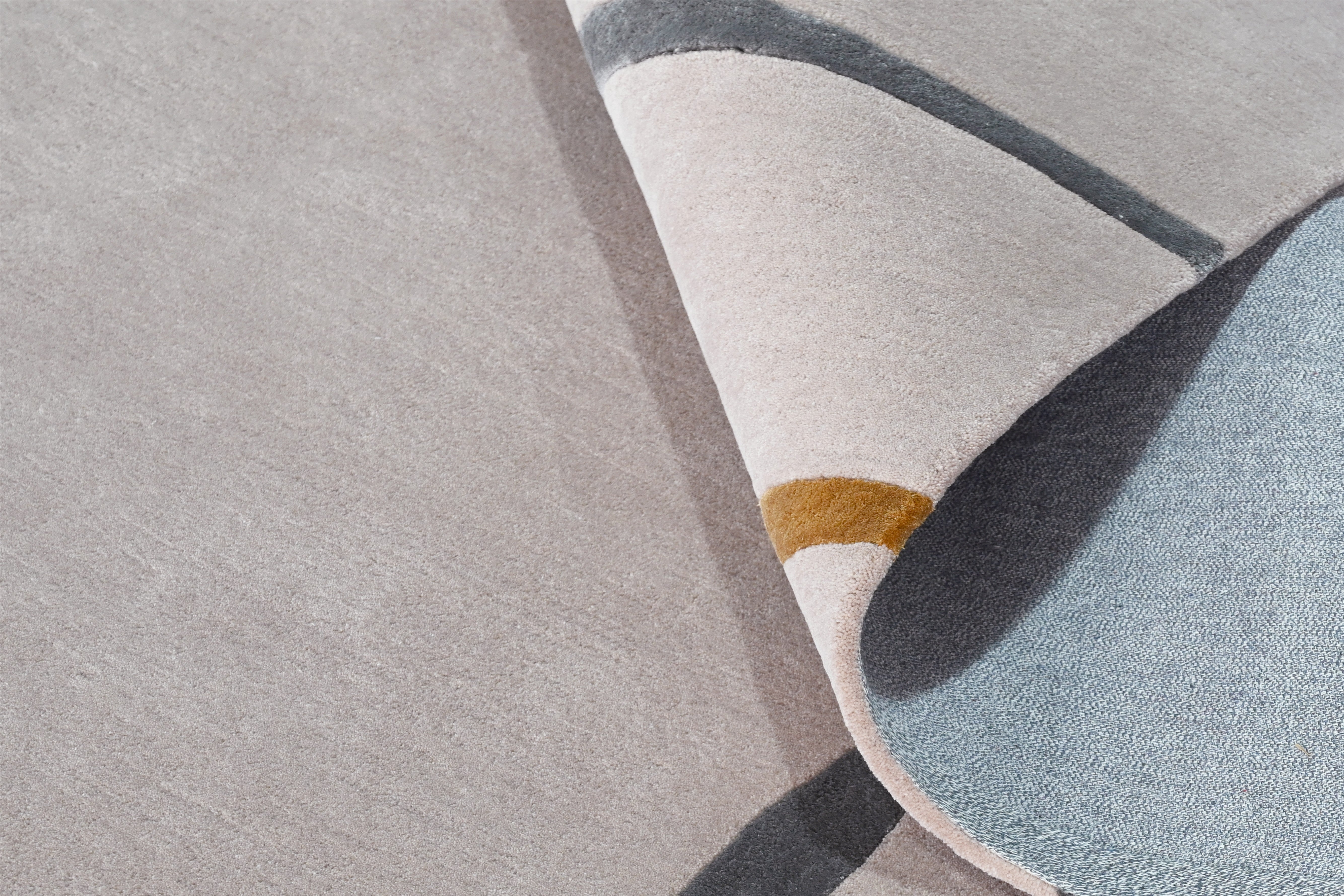 Close-up of Muted Motion Rug surface showing soft hand tufted wool finish.