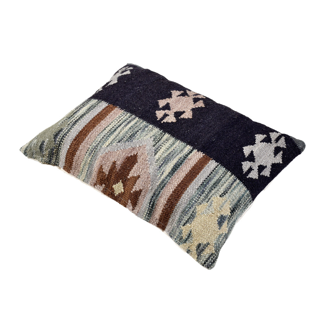 Angled view of the Nordic Tribal flatweave wool pillow showcasing its tribal pattern and textured weave.