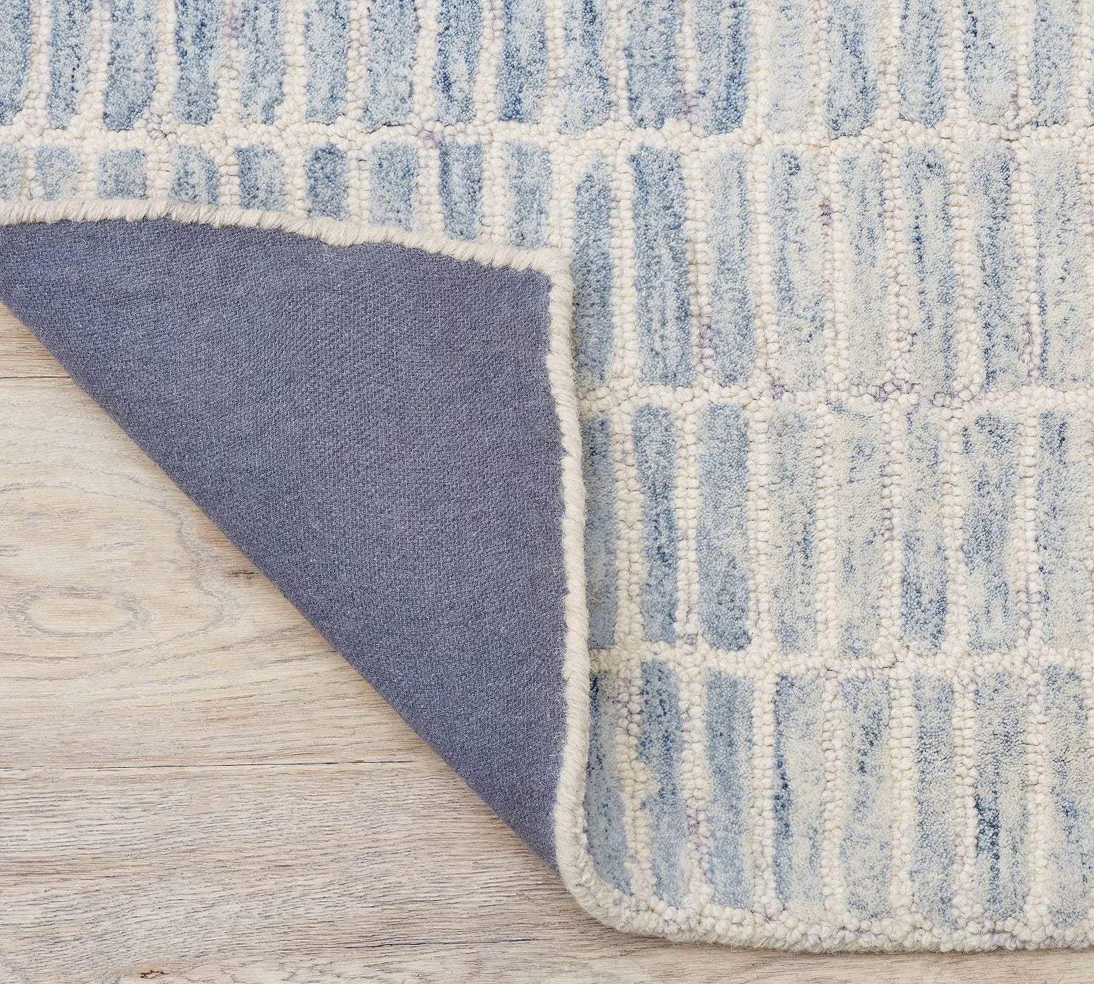 Folded edge of Ocean Breeze Rug displaying hand tufted detail