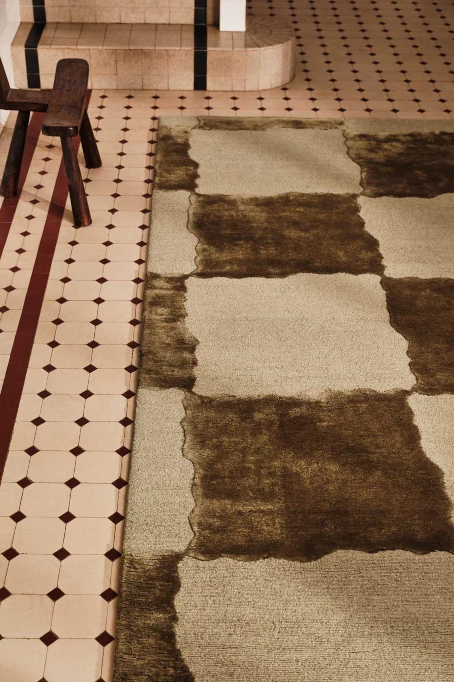 Rug placed with rustic chair highlighting earthy checks.