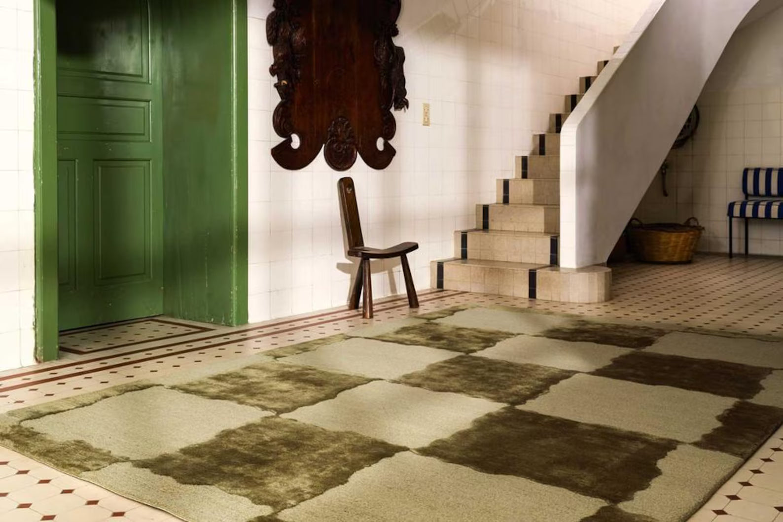 Olive Grid Rug styled in a modern entryway with wooden chair and green door.