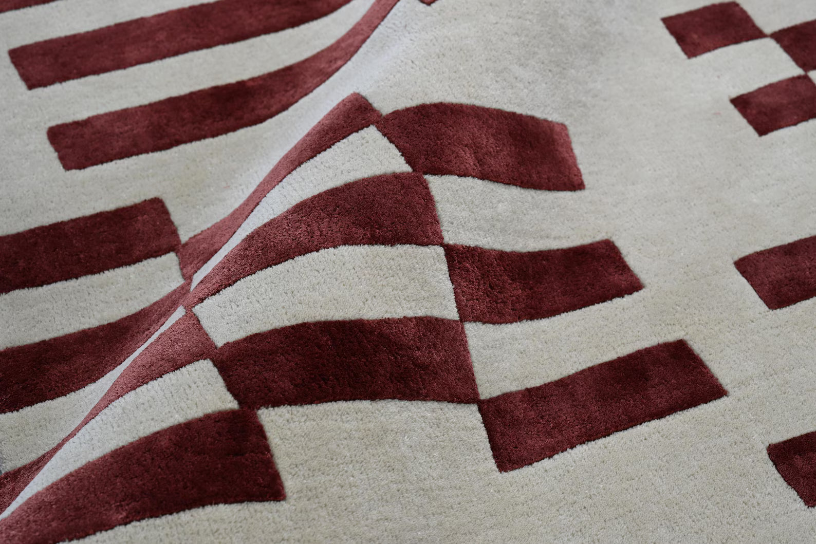 Close-up of the Pixelated Rug corner, highlighting the sharp red grid lines on beige.