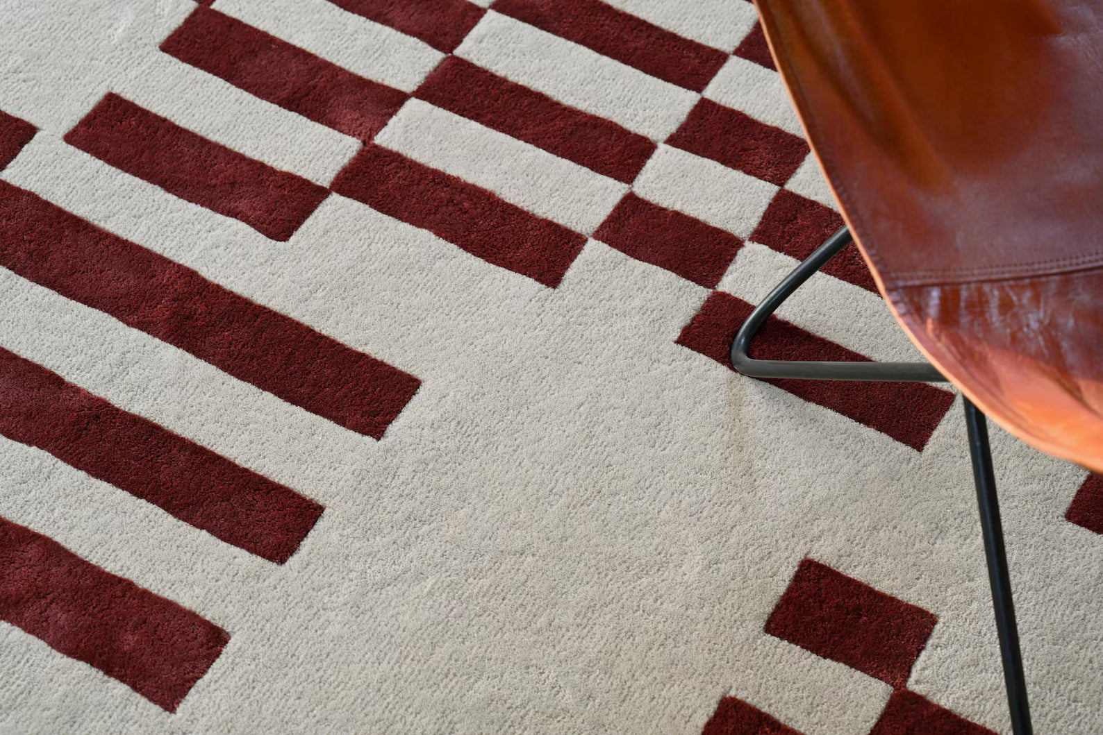 Pixelated Rug pattern with geometric burgundy lines.