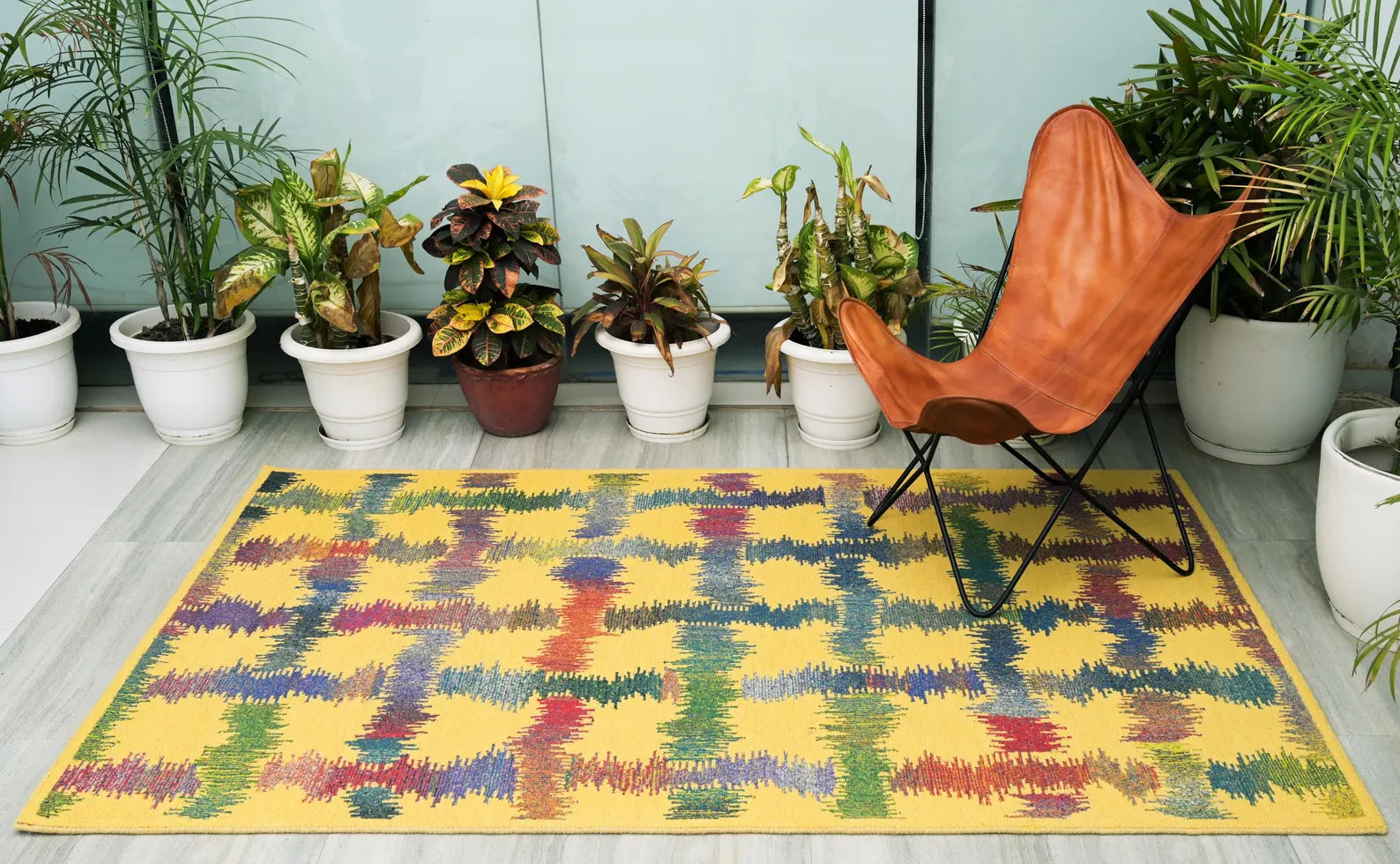 Radiance Flow Rug styled outdoors with planters and seating.