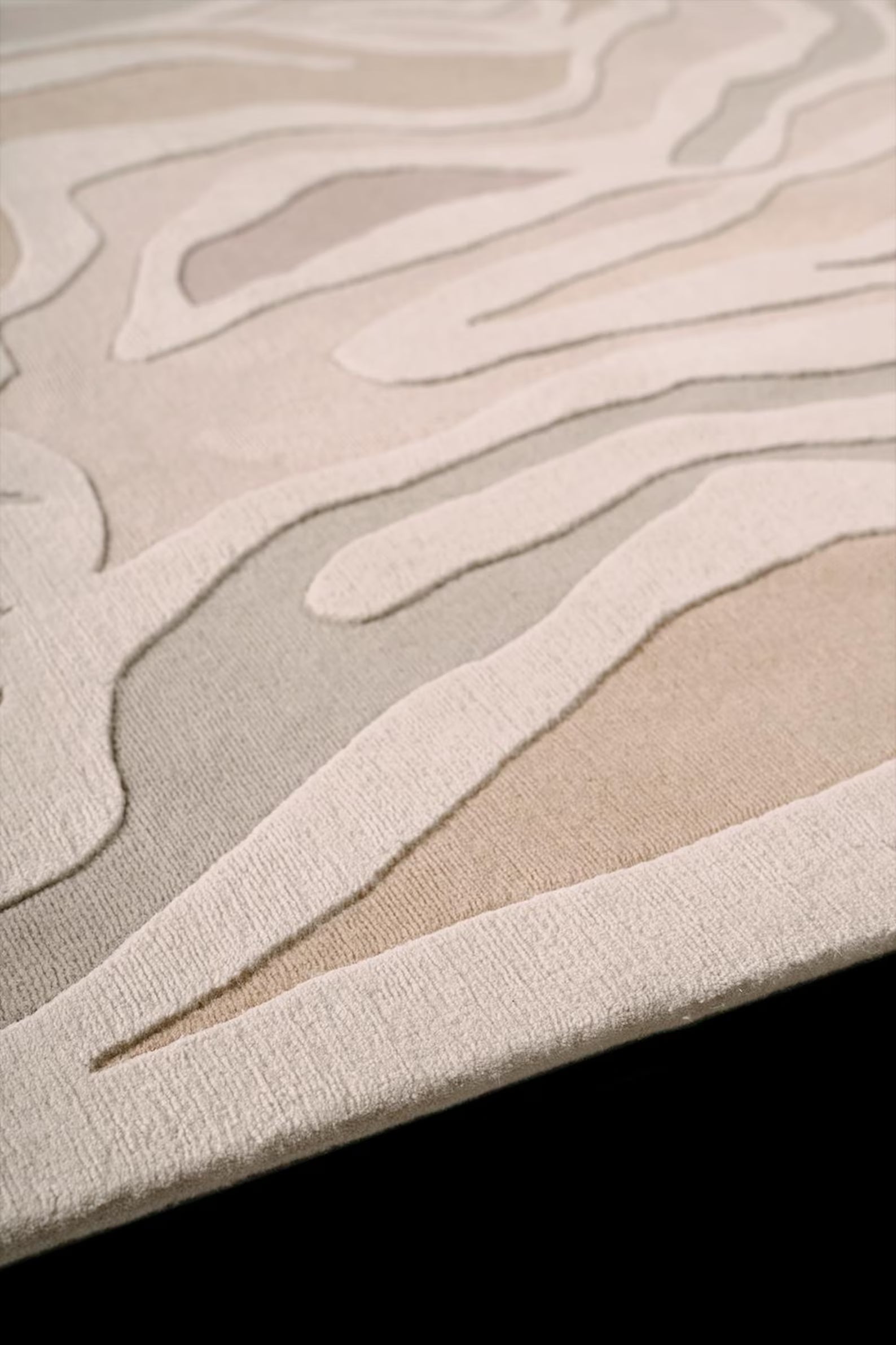 Detailed edge view of Sandstone Swirl rug with curved organic wool pattern – Decordec