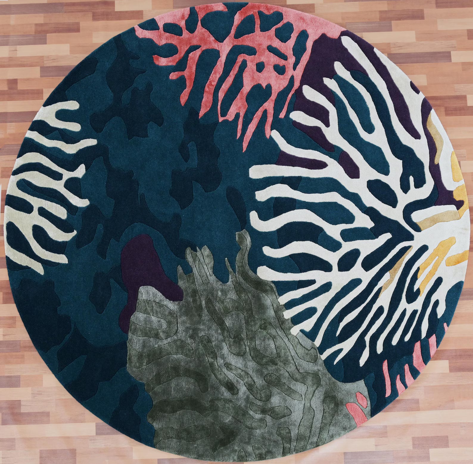 Seaform Hand tufted Rug full top view showing ocean flora inspired pattern in shades of blue, ivory, green, coral, and gold on wooden flooring