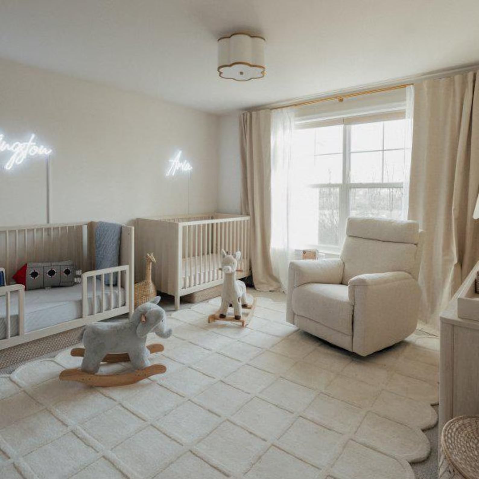 Seraphine Rug placed in a soft beige twin nursery with cribs, rocking horses, and warm natural light highlighting its scalloped border and plush grid pattern.