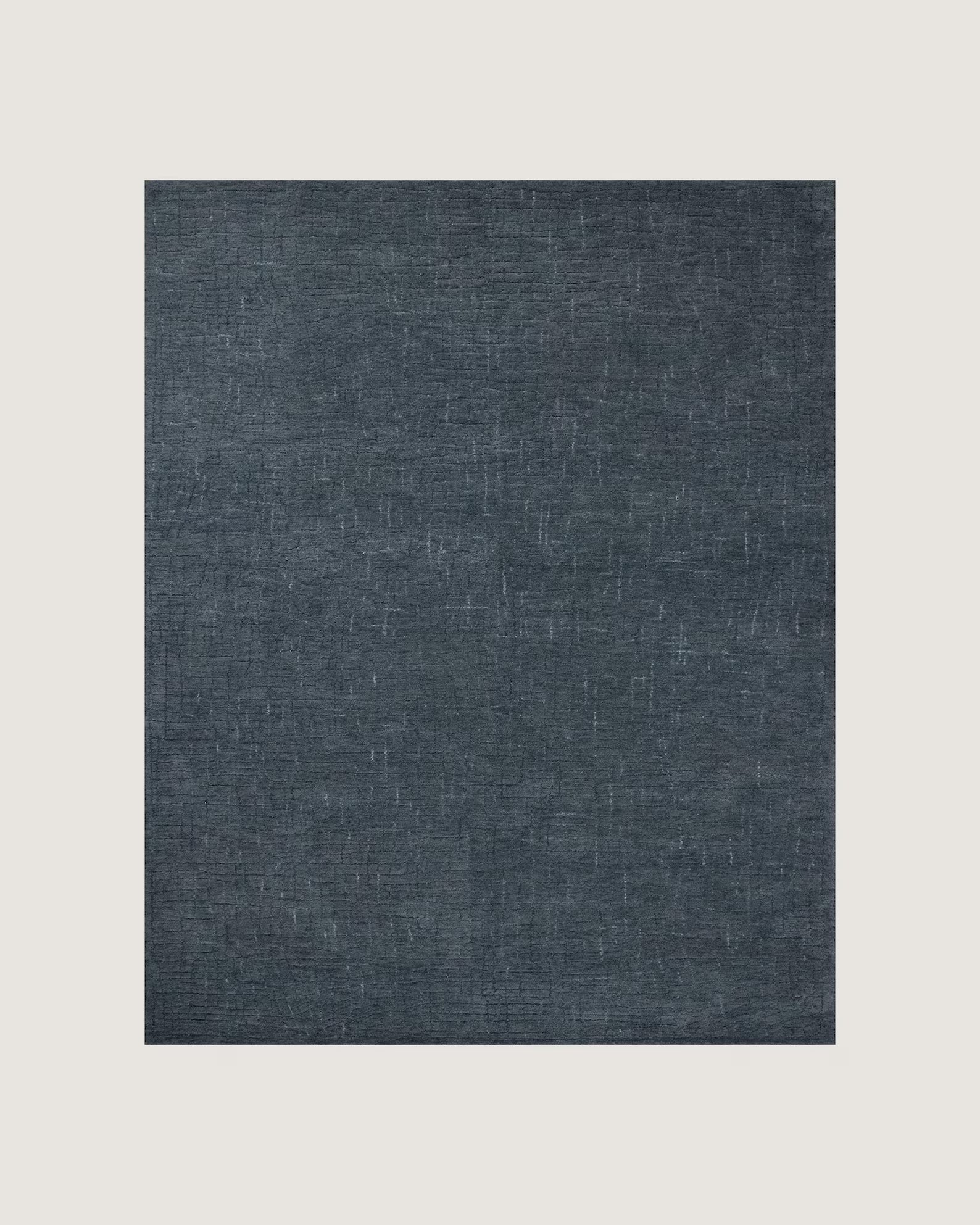 : Overhead flatlay of the Serenity Textured Rug showing its fine woven detailing and deep blue texture on a wooden floor.