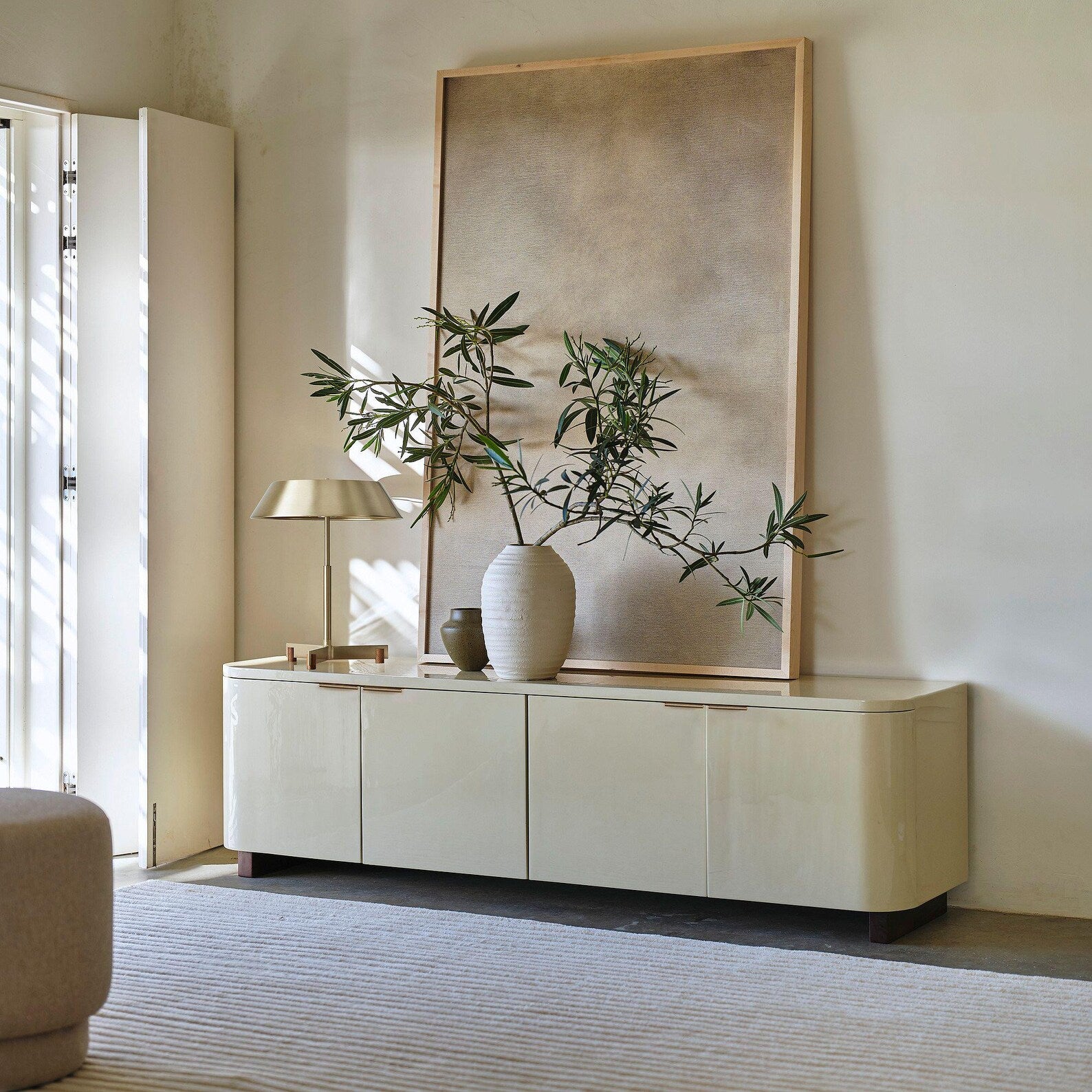 Spacious beige-toned living area featuring Softwave Rug with subtle linear texture, modern furniture, and warm natural light.