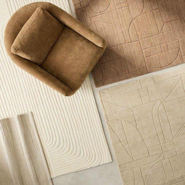 Softwave Rug styled with neutral home décor pieces, showing smooth wave pattern and soft off-white tone on hardwood floor.