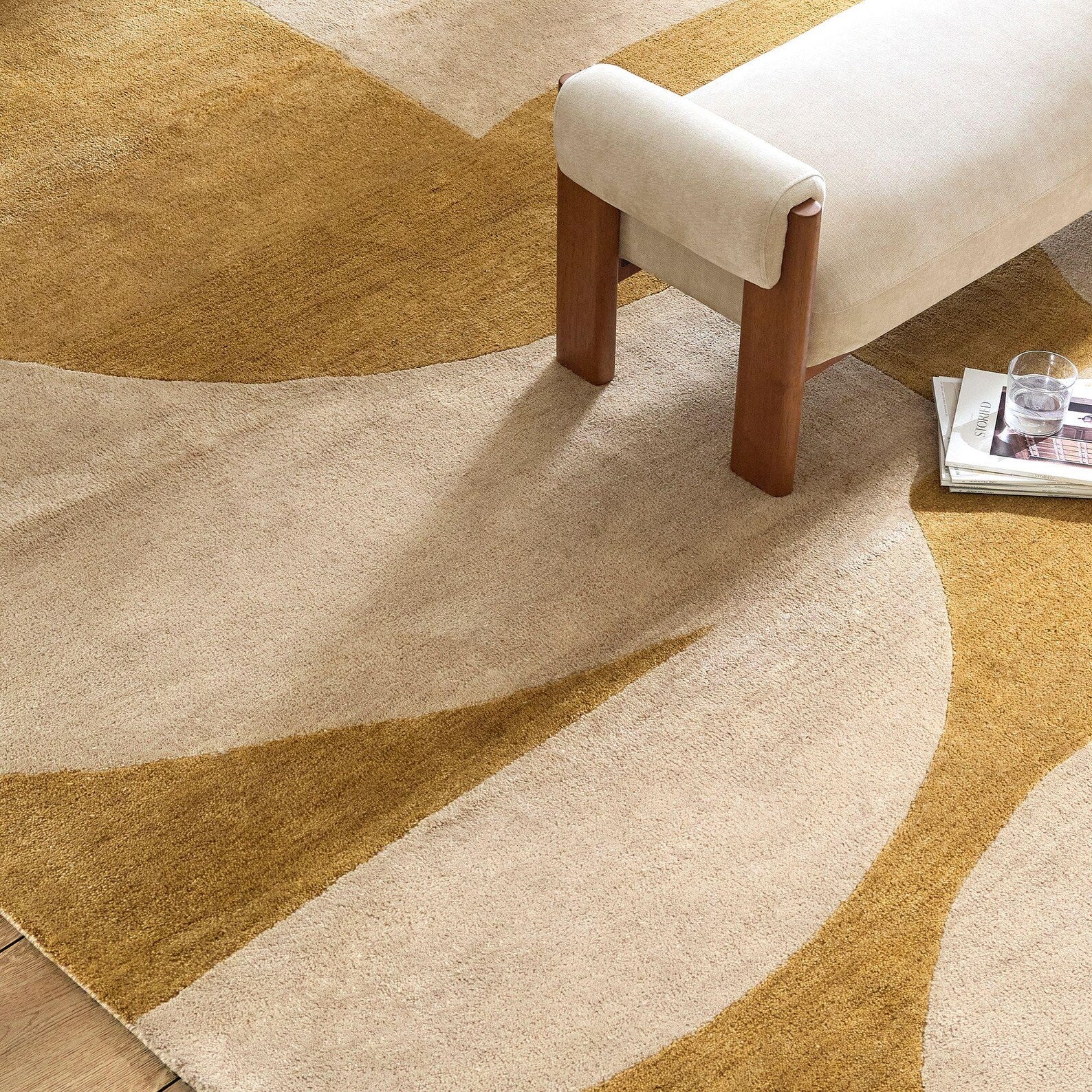 Solara Rug styled in a modern living room, showing golden and beige arc patterns.