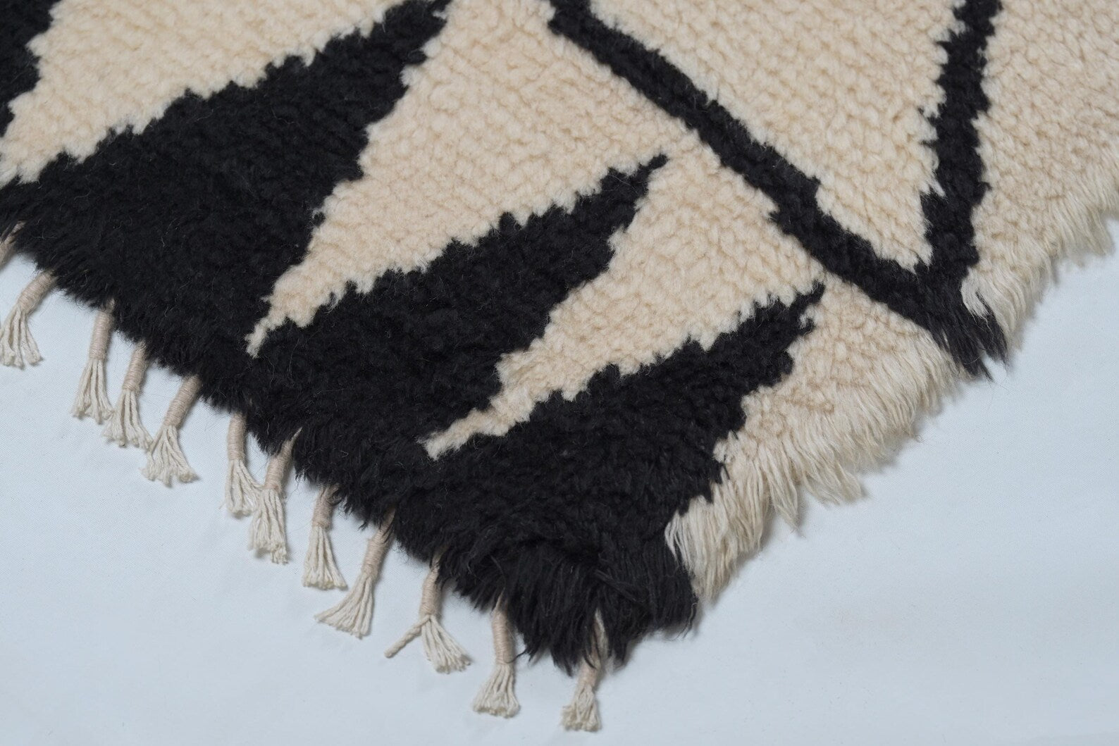 Close-up of Stemline Rug showing precise line detailing and hand-woven cream background.