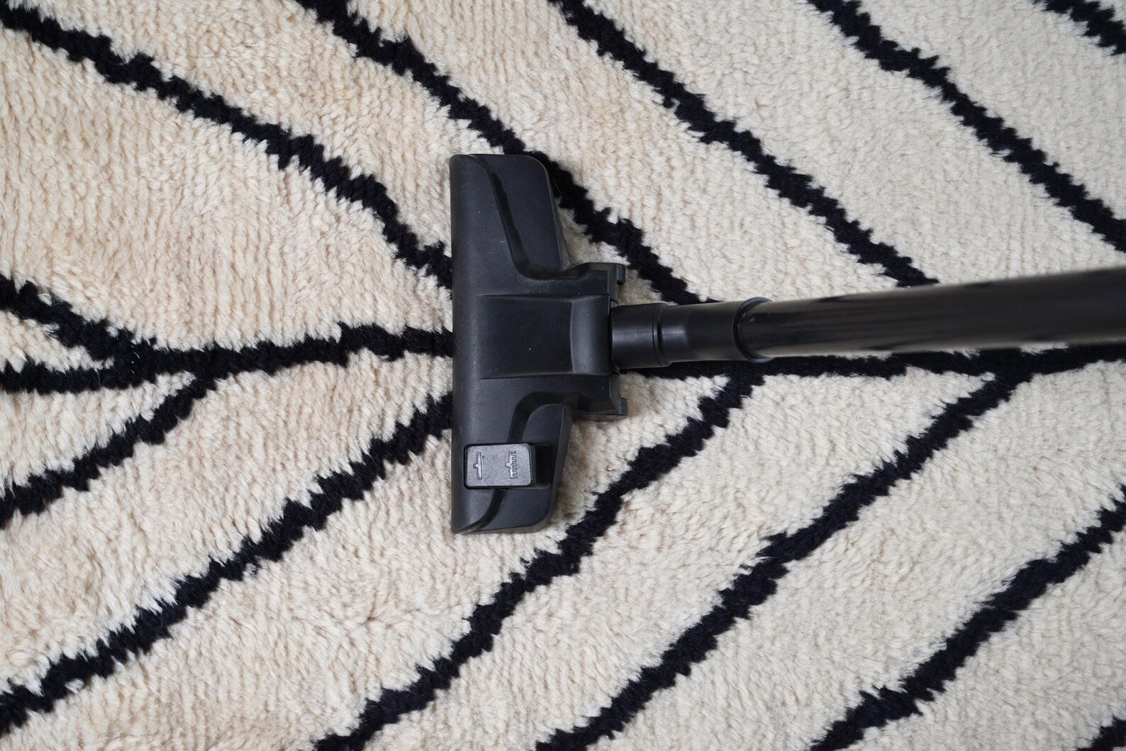 Corner detail of Stemline Rug highlighting geometric black lines and smooth flat-woven texture.