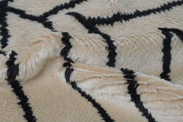 Product tag close-up of Stemline Rug showing brand label and hand-finished detailing.