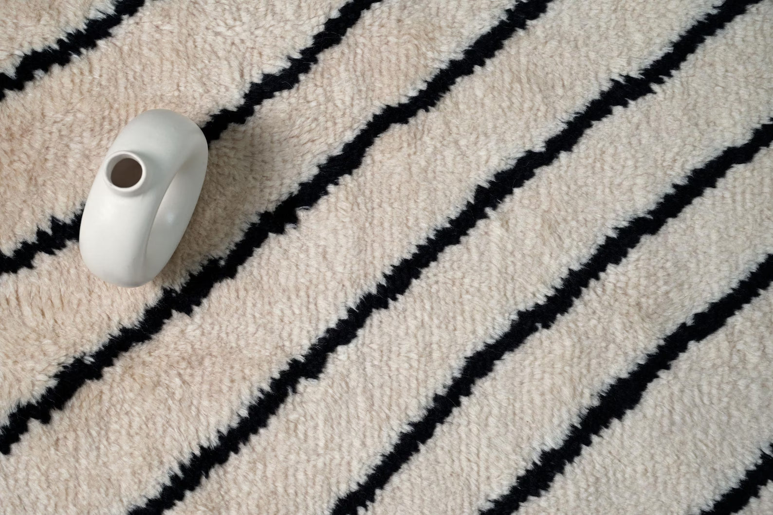 Stemline Moroccan_hand_knotted Rug styled in a modern interior with warm tones emphasizing its clean linear pattern.