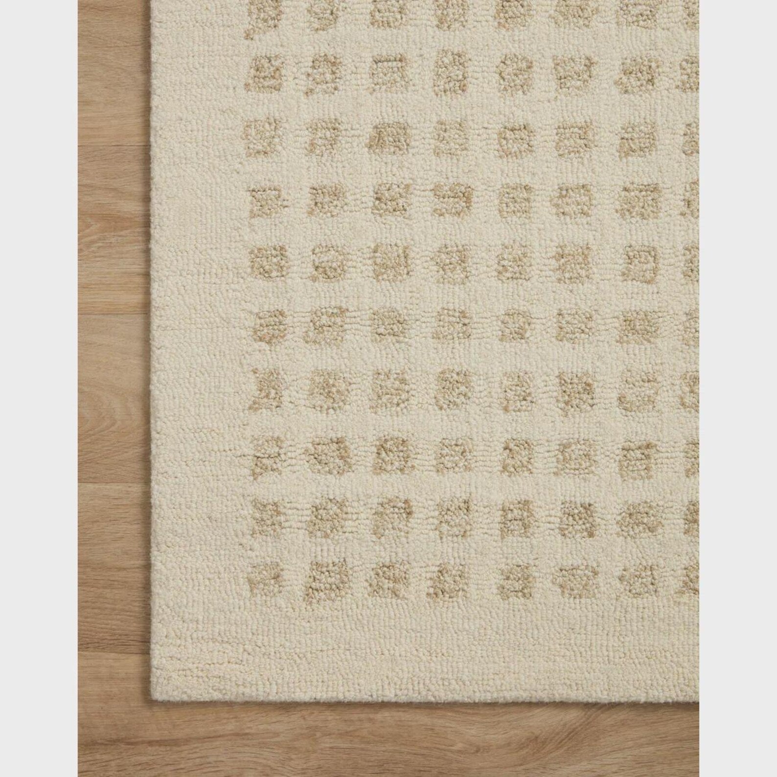 Side view of the Tessel hand tufted rug highlighting its fine woven edges and precise square detailing.