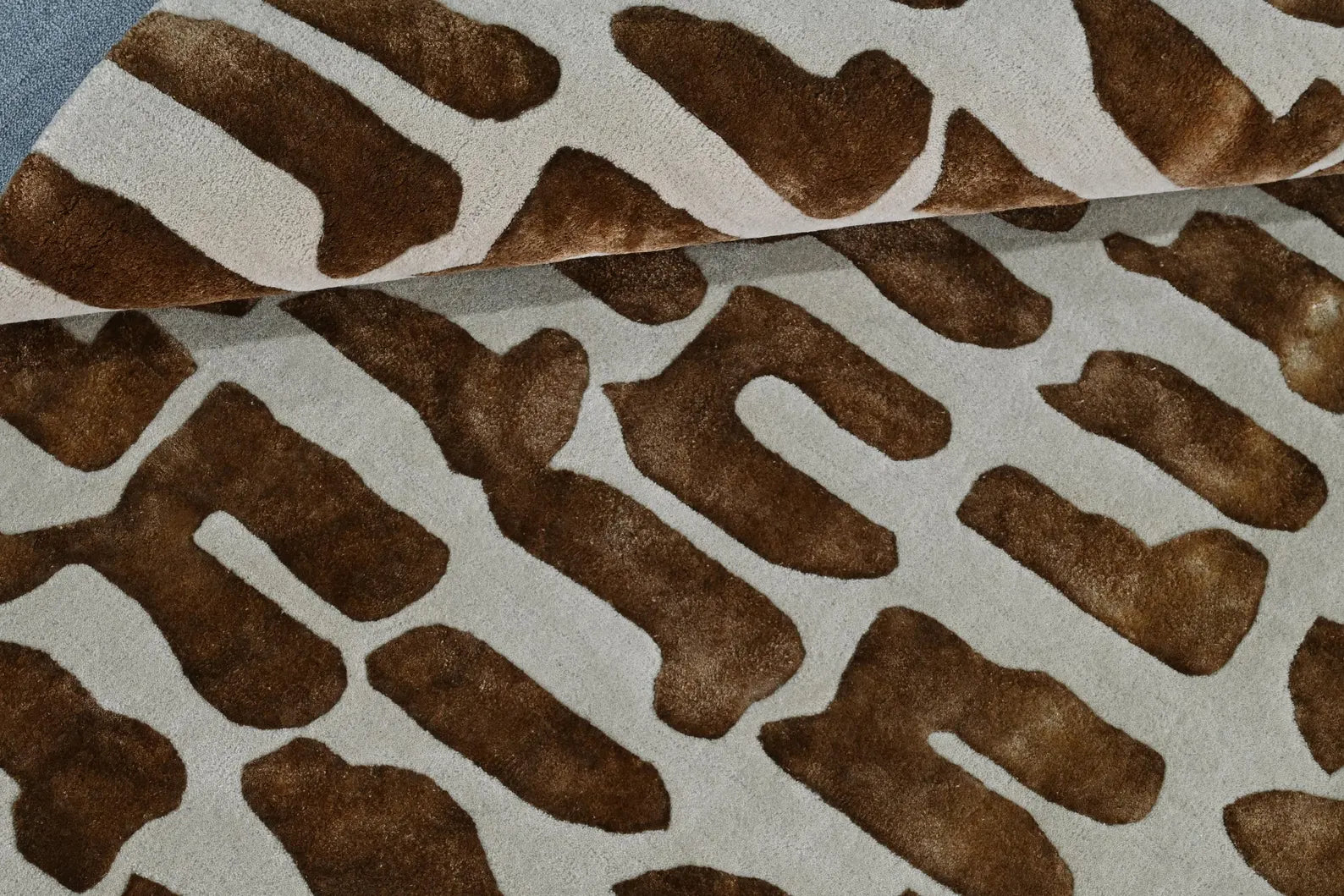 Texture close-up view of Modern Tribal Rug showing detailed brown tribal motifs on cream base with raised hand-tufted surface