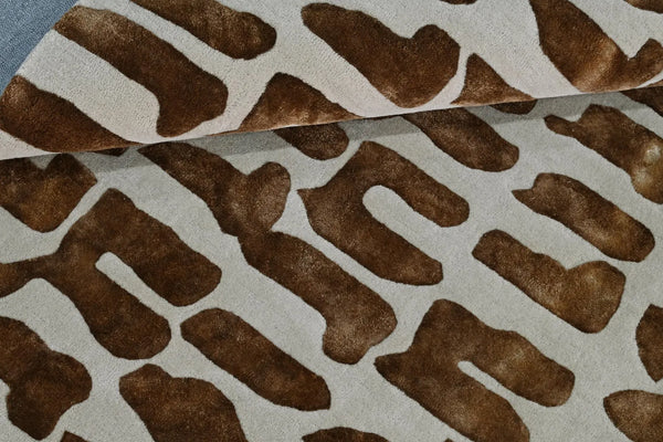 Texture close-up view of Modern Tribal Rug showing detailed brown tribal motifs on cream base with raised hand-tufted surface