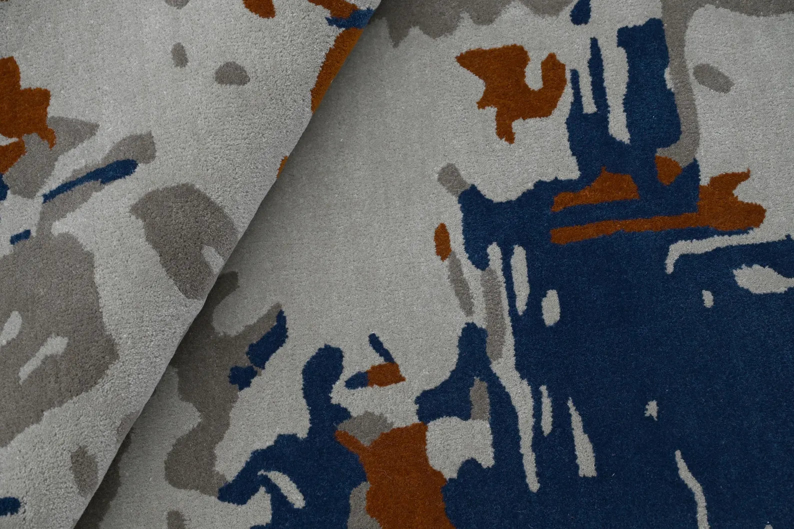 Macro texture view of the Textured Abstract Rug with raised hand-tufted surface in distressed design.