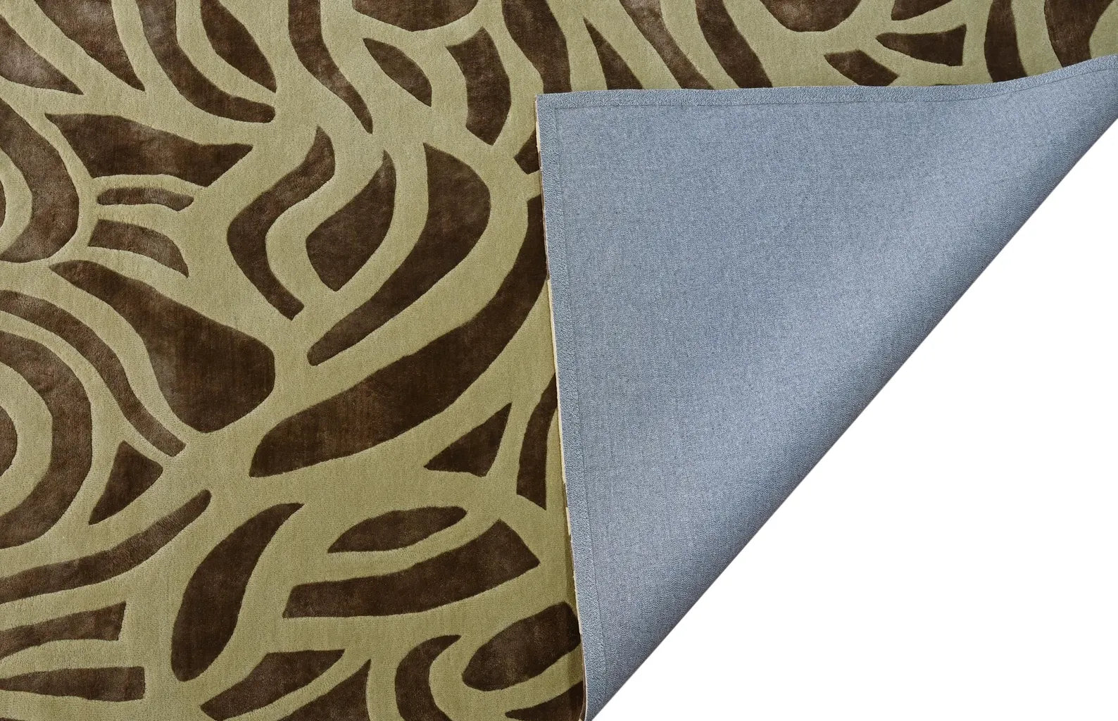 Verona hand tufted rug folded from the side showing both its textured surface pattern and visible cotton backing with clean edge finishing.