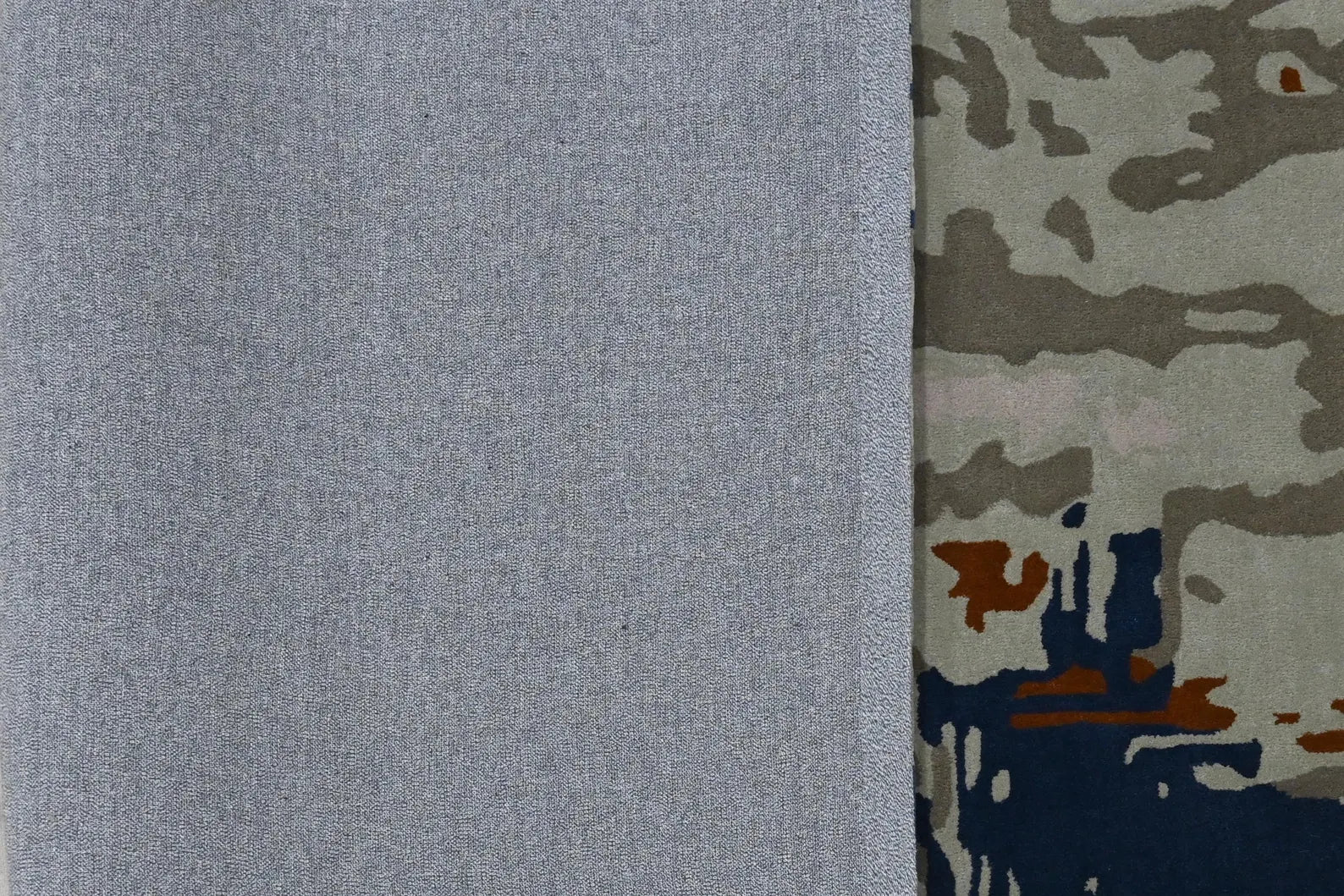 Folded edge of Vortex Distressed Rug displaying soft backing and distressed multi-color pattern.